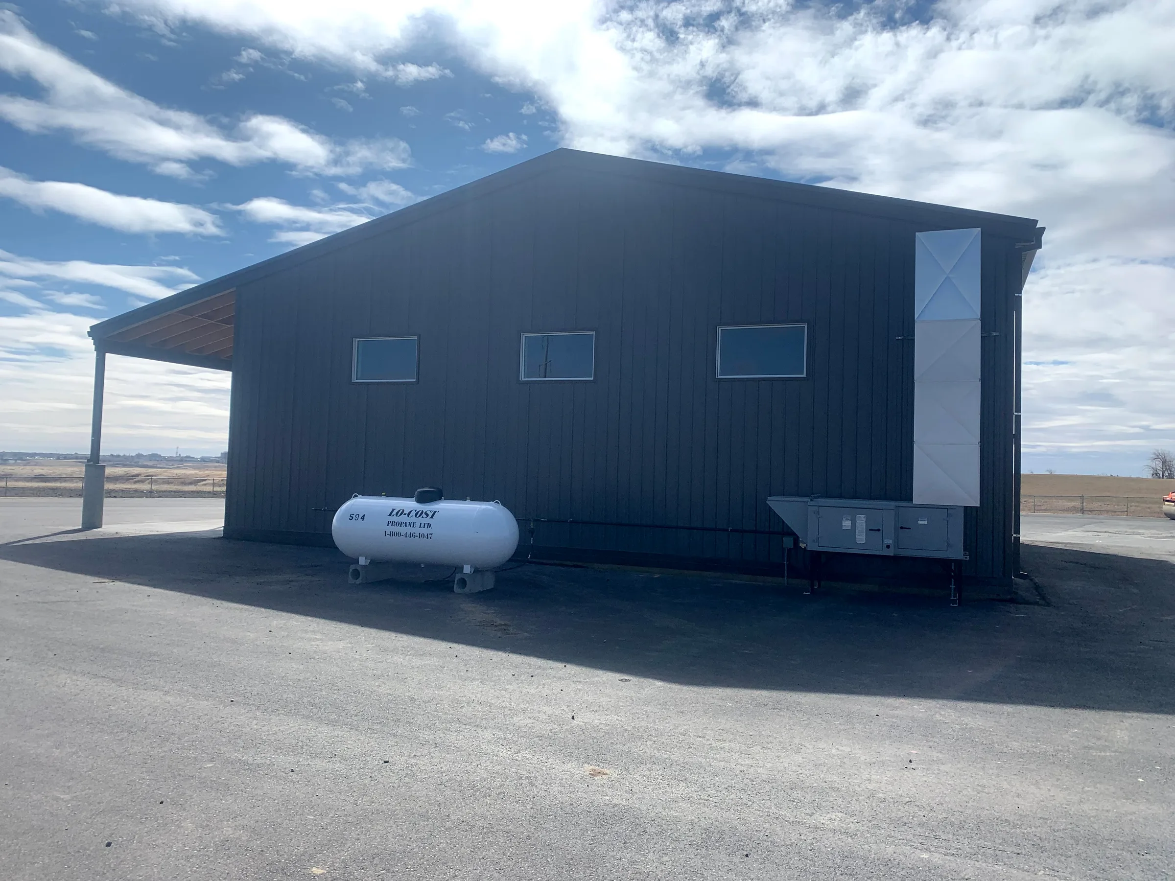 Side of the completed steel depot building with ribbed metal cladding and a covered bay at City of Lethbridge Transportation Depot, built by Premiere Builders