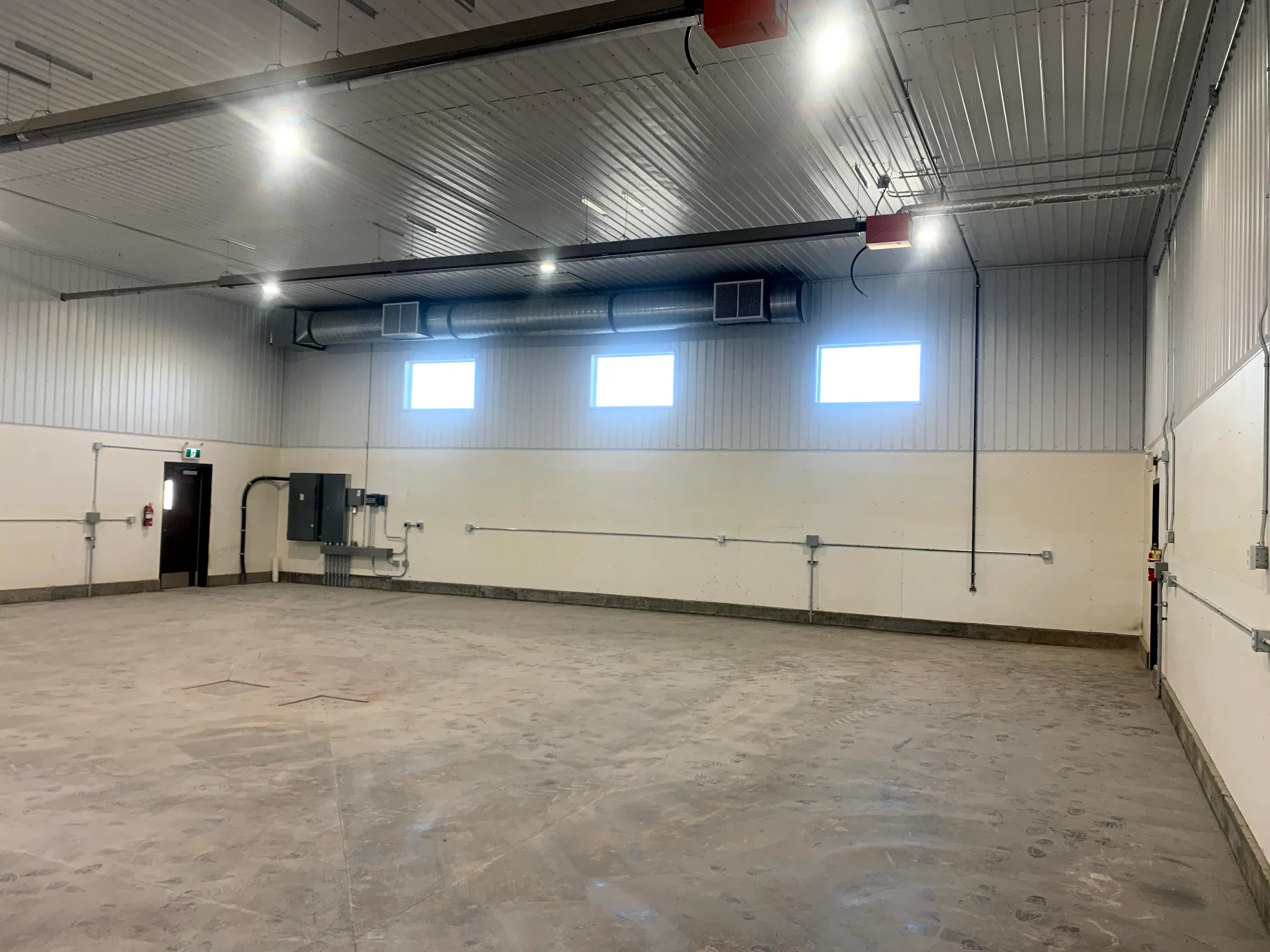 Open shop bay interior with liner panel walls, high windows and overhead heaters at City of Lethbridge Transportation Depot, built by Premiere Builders