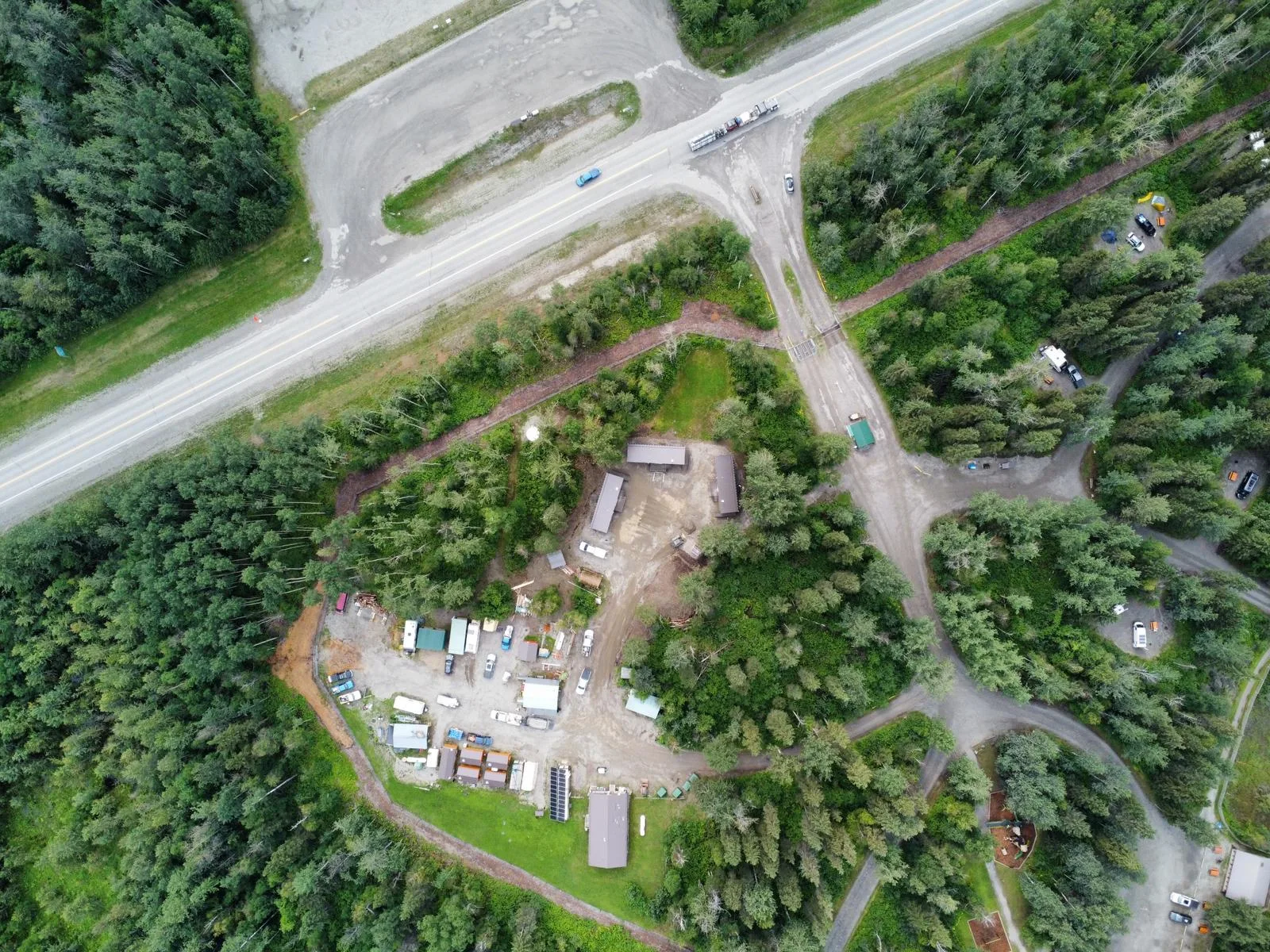 Aerial view of the camp site beside a highway, surrounded by dense boreal forest at Liard River Park Ranger Cabins, built by Premiere Builders
