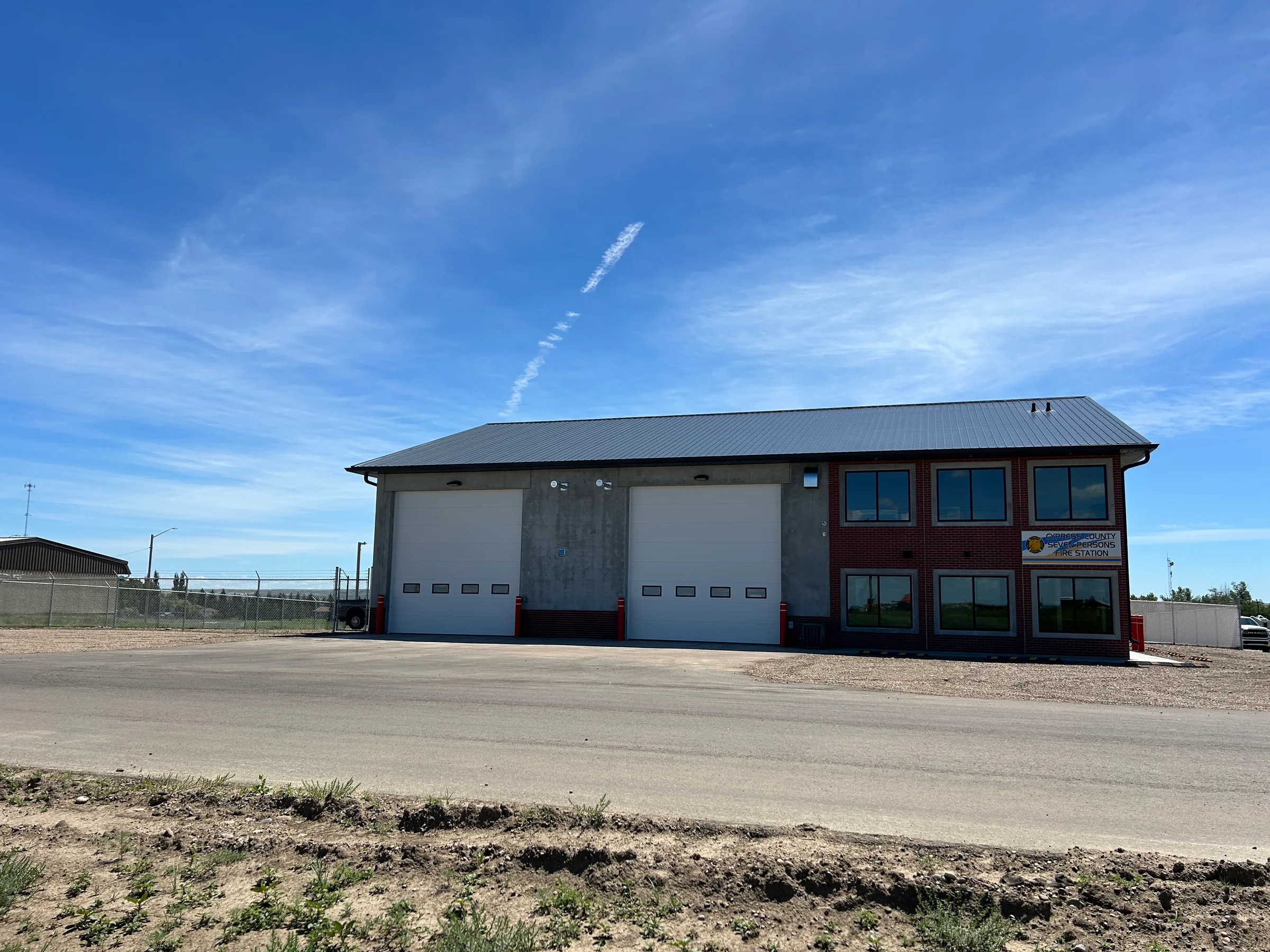 Front view of the finished fire station with apparatus bays and brick-clad office section at Seven Persons Fire Hall, built by Premiere Builders
