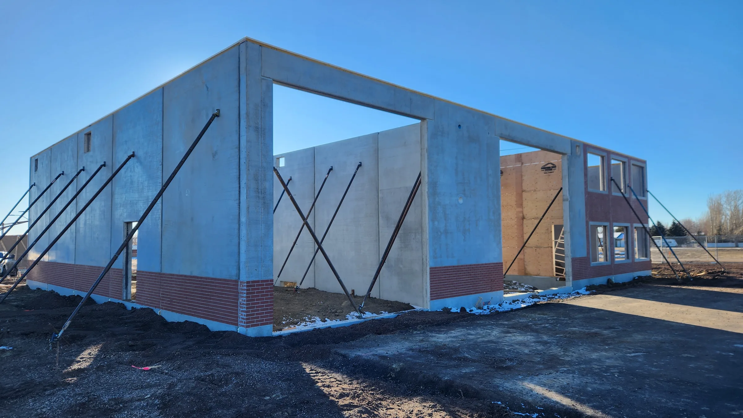 Braced precast concrete wall panels with brick base framing the apparatus bay openings at Seven Persons Fire Hall, built by Premiere Builders
