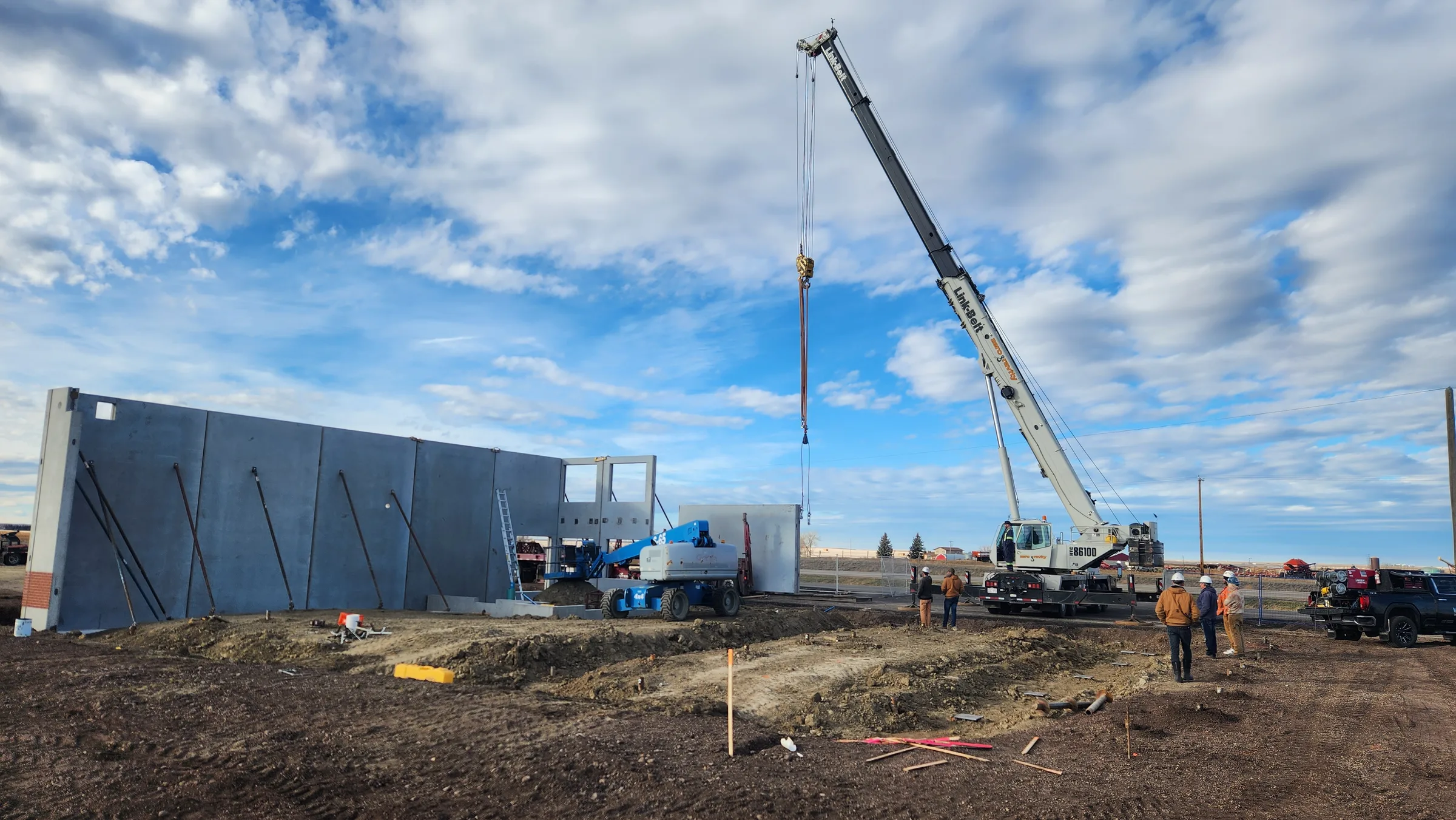 Crane lifting precast concrete wall panels into place during fire hall construction at Seven Persons Fire Hall, built by Premiere Builders